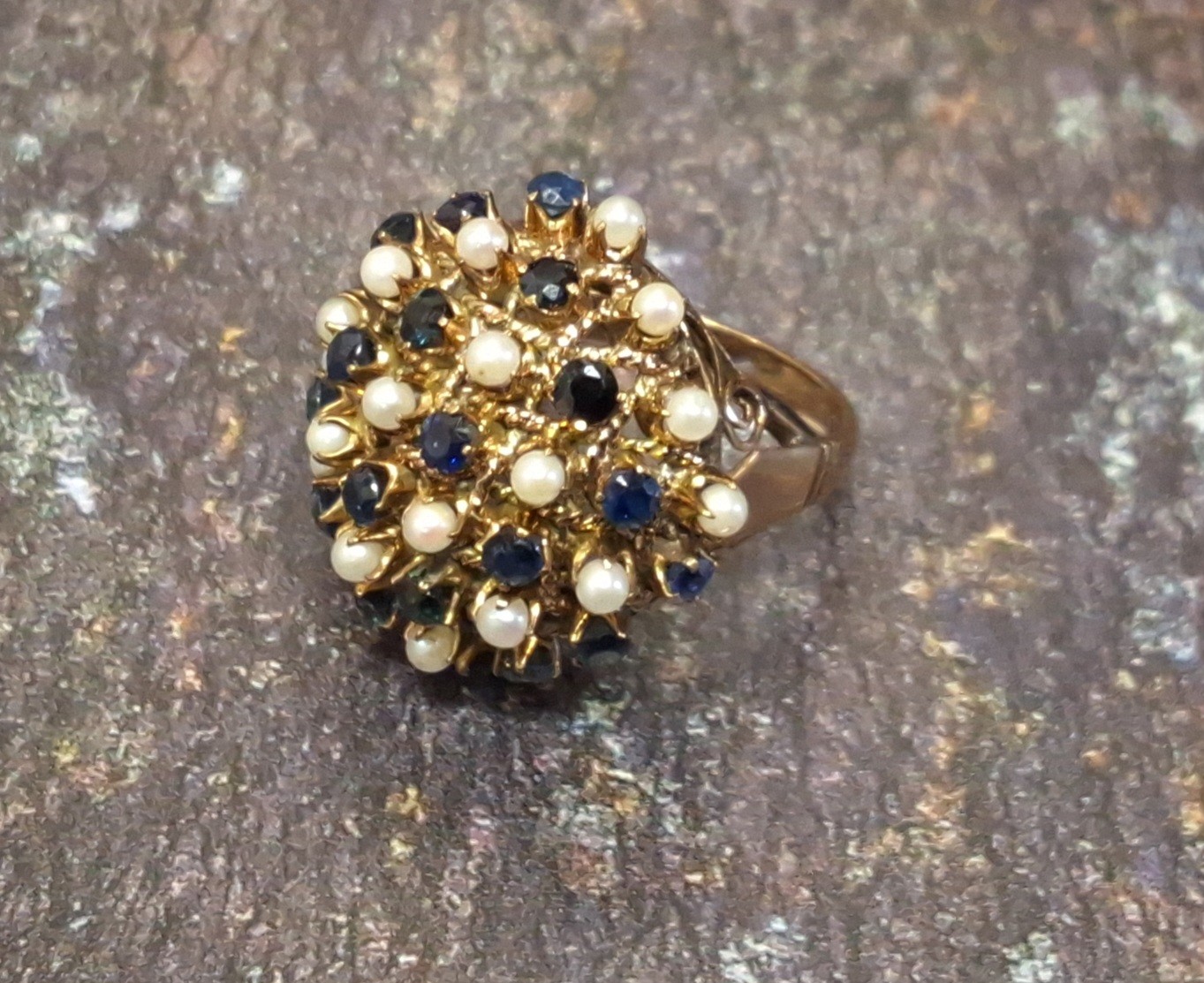 An unusual 14k sapphire and seed pearl cluster ring in the form of a flower frog set with