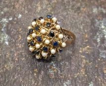 An unusual 14k sapphire and seed pearl cluster ring in the form of a flower frog set with