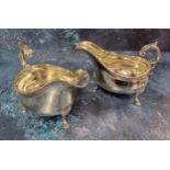 A pair of Edwardian silver sauce boats, beaded rim, c-scroll handle with leaf detail, raised on