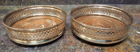 A pair of George III style silver bottle coasters, pierced bowed sides, draught turned bases, 13.