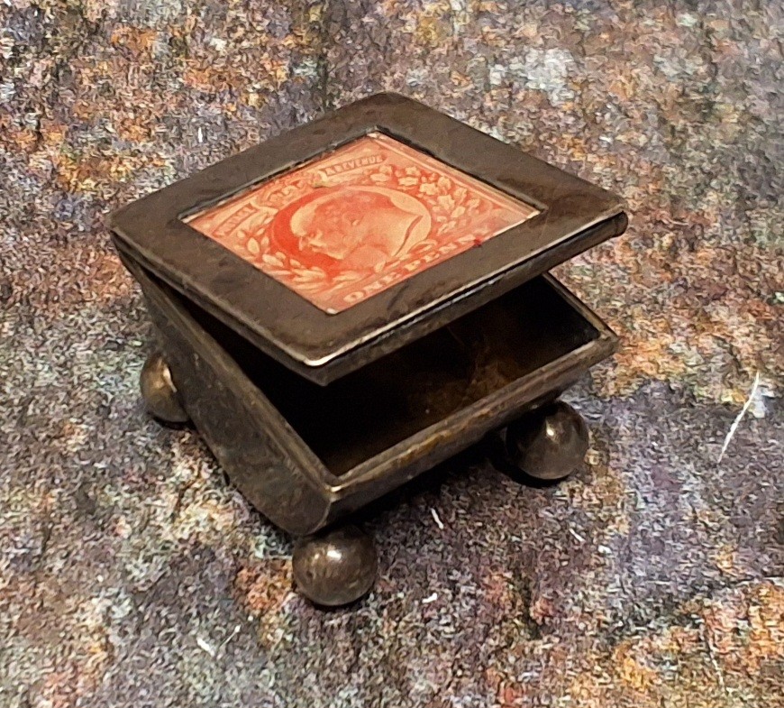 An Edwardian silver stamp box, the cover set with Penny Red, ball feet, 3cm wide, Birmingham 1903