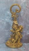 A Victorian brass door stop, cast with a cherub and scrolling foliage, 49cm high, c.1860