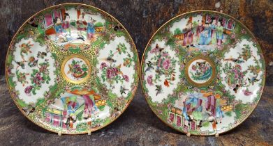 A pair of Chinese famille rose circular plates, decorated with alternating panels of figures,