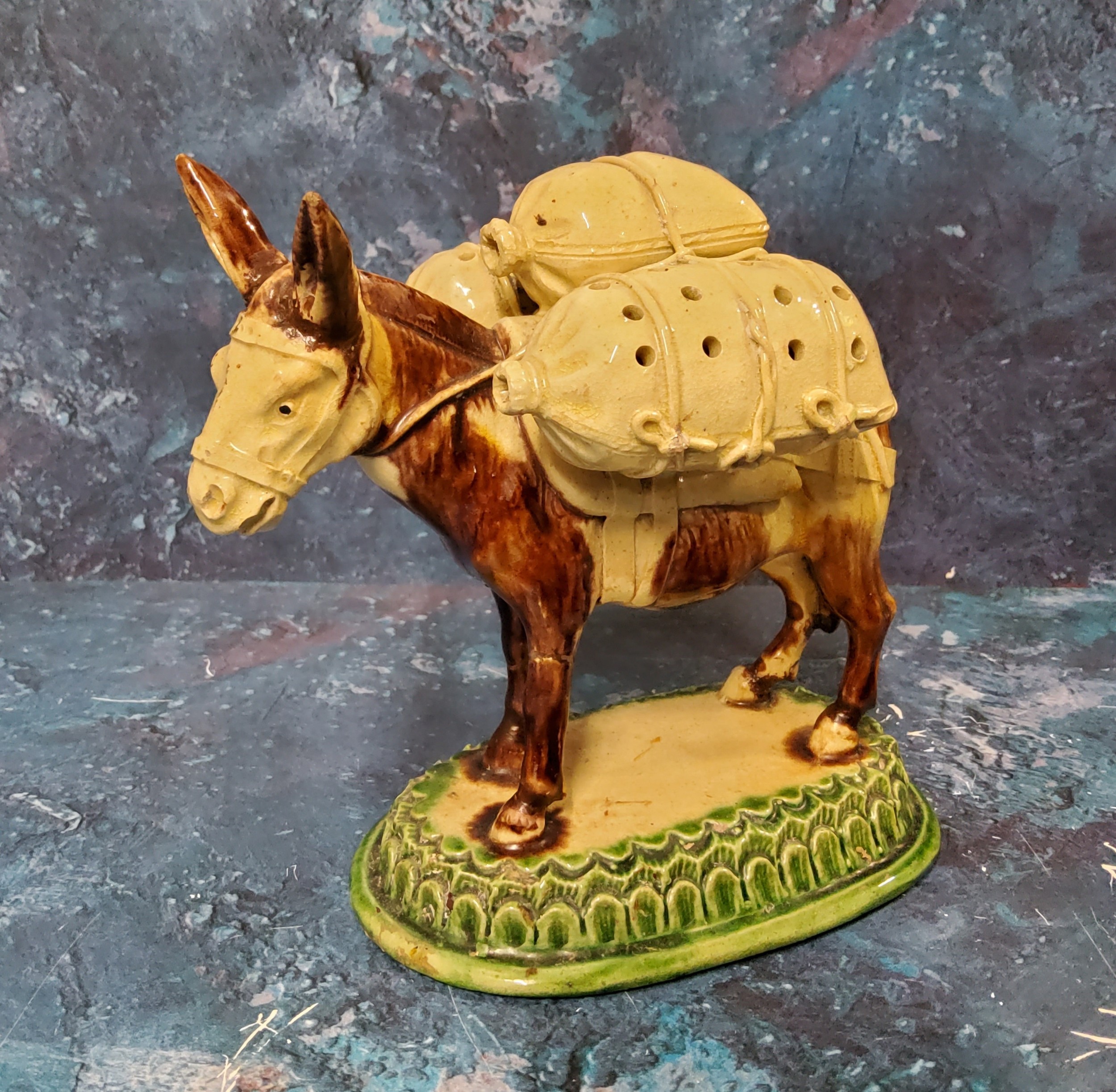 A Portuguese novelty tooth pick holder, in the form of a donkey, laden with three sacks, oval