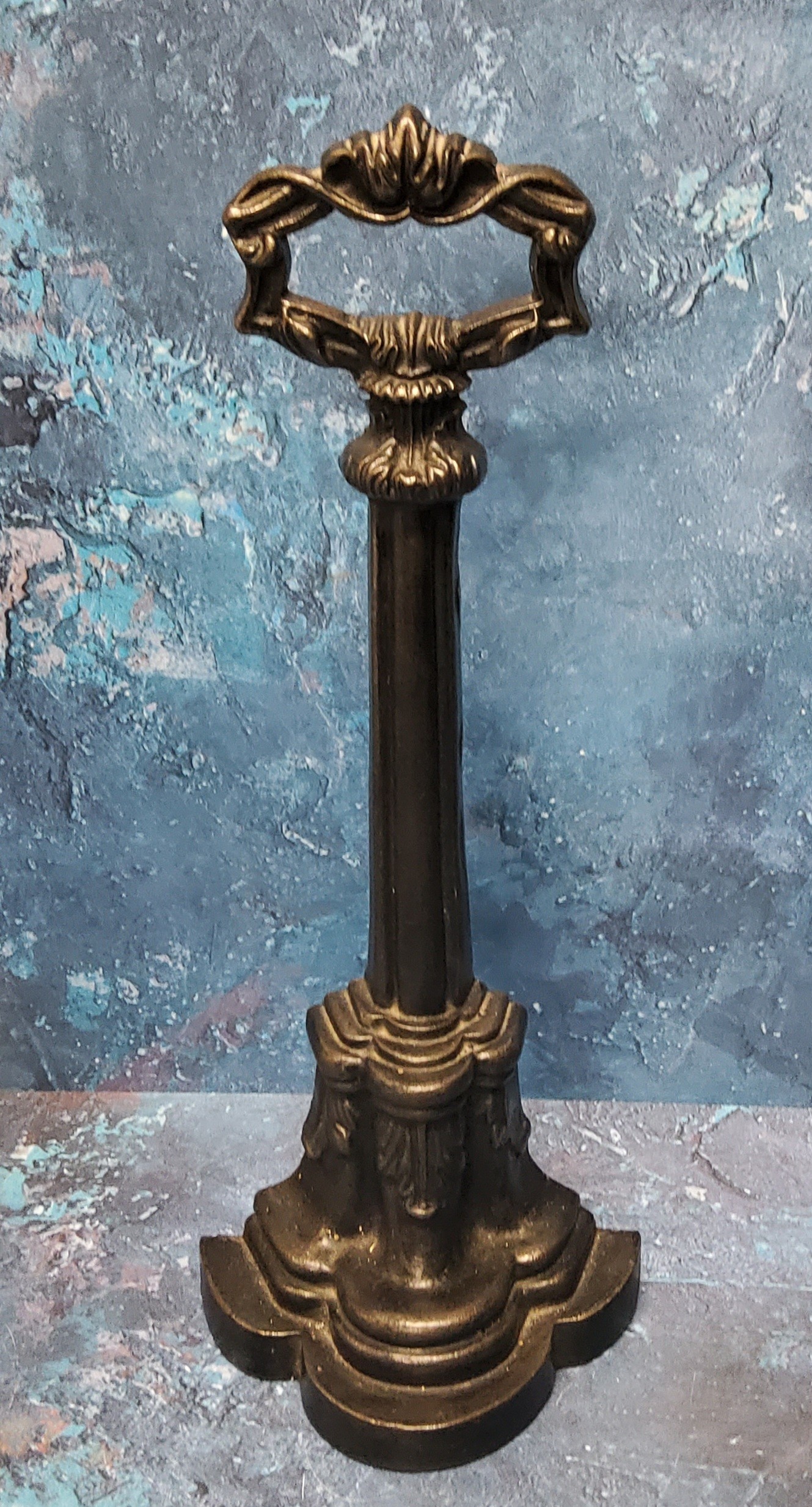 A Victorian cast iron door stop, posted handle, the demi-lune base cast with acanthus, signed