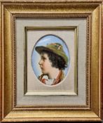 A 19th century German porcelain oval plaque, probably Berlin, portrait of a young boy wearing a hat,