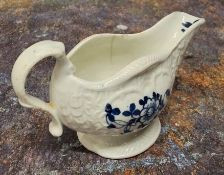 A Liverpool James Pennington strap moulded creamboat, painted in underglaze blue with flowers,