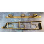 A 19th century brass three gun wall hanging rack, 49cm long