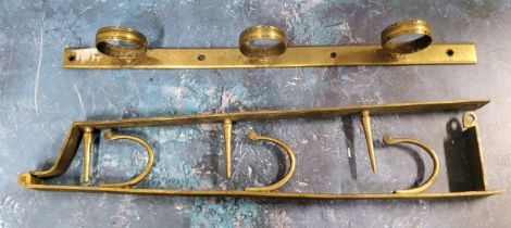 A 19th century brass three gun wall hanging rack, 49cm long