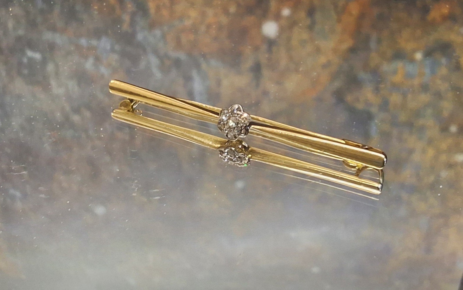 An 18ct gold and diamond cluster bar brooch, set with seven brilliant cut stones, 9cm long, 4.4g,