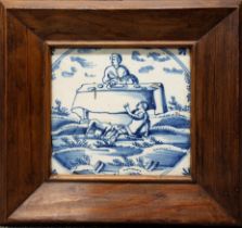 An 18th century Delft tile, decorated in underglaze blue with a person seated at a table, another on