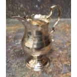 A George III silver pedestal cream jug, acanthus-capped scroll handle, shaped circular foot, stipple