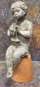 A 19th century lead garden figure, of a scantily clad cherub playing Pan pipes, seated on a upturned