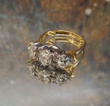 An impressive 18ct gold diamond ring, the central claw set oval diamond , flanked by two smaller