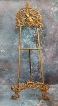 A Victorian brass easel, cast with cherub and leafy scrolls, 59cm high, c.1870