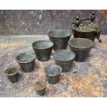 A set of eight Nuremberg type bronze nesting cup weights, from 2/10 to 10oz Troy, the largest 7cm