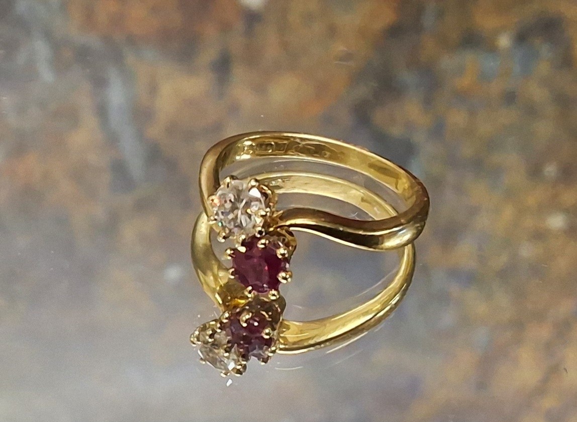 An 18ct gold diamond and ruby ring, the claw set diamond approx 0.25ct and the round ruby set on a