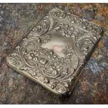 An Edwardian silver rounded rectangular visiting card case, embossed with  leafy scrolls and