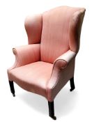 A George III mahogany wingback armchair, pinstriped pink upholstery, fluted stile legs, brass