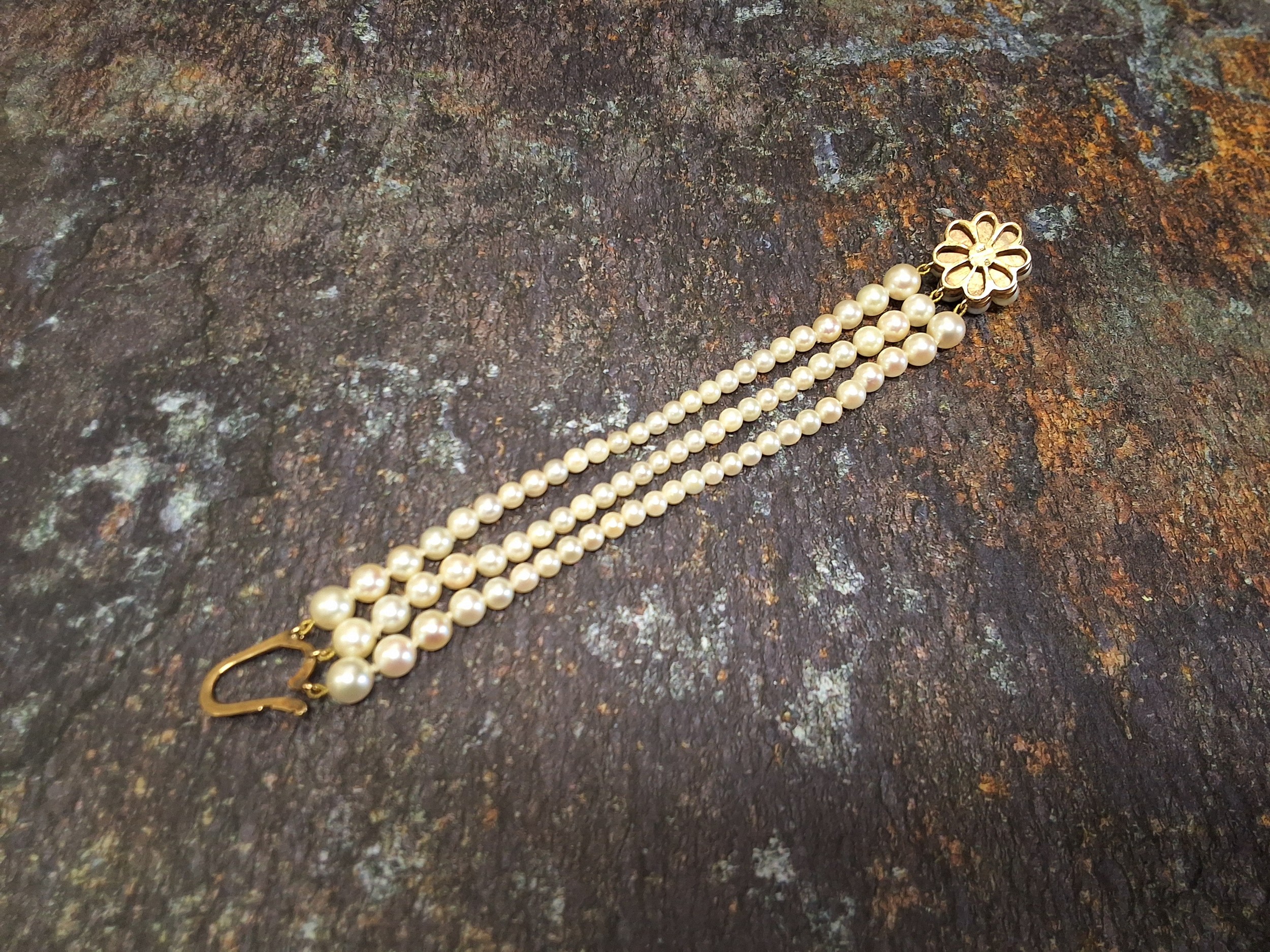 A 9ct gold three stand graduated pearl bracelet, the largest 6.9mm to 4.1mm, the 9ct gold clasp in - Image 2 of 3
