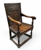 A late 17th century oak wainscot chair, with a lozenge carved panelled back and plank seat on turned