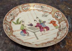 An 18th century Chinese plate, painted in polychrome with figures playing a game, the rim with