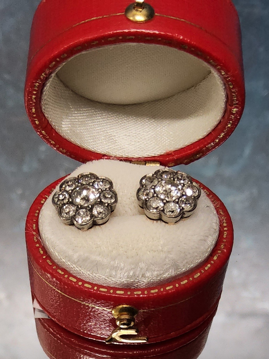 A pair of 18ct gold & diamond cluster earrings, each set with a central round diamond approx. 0.