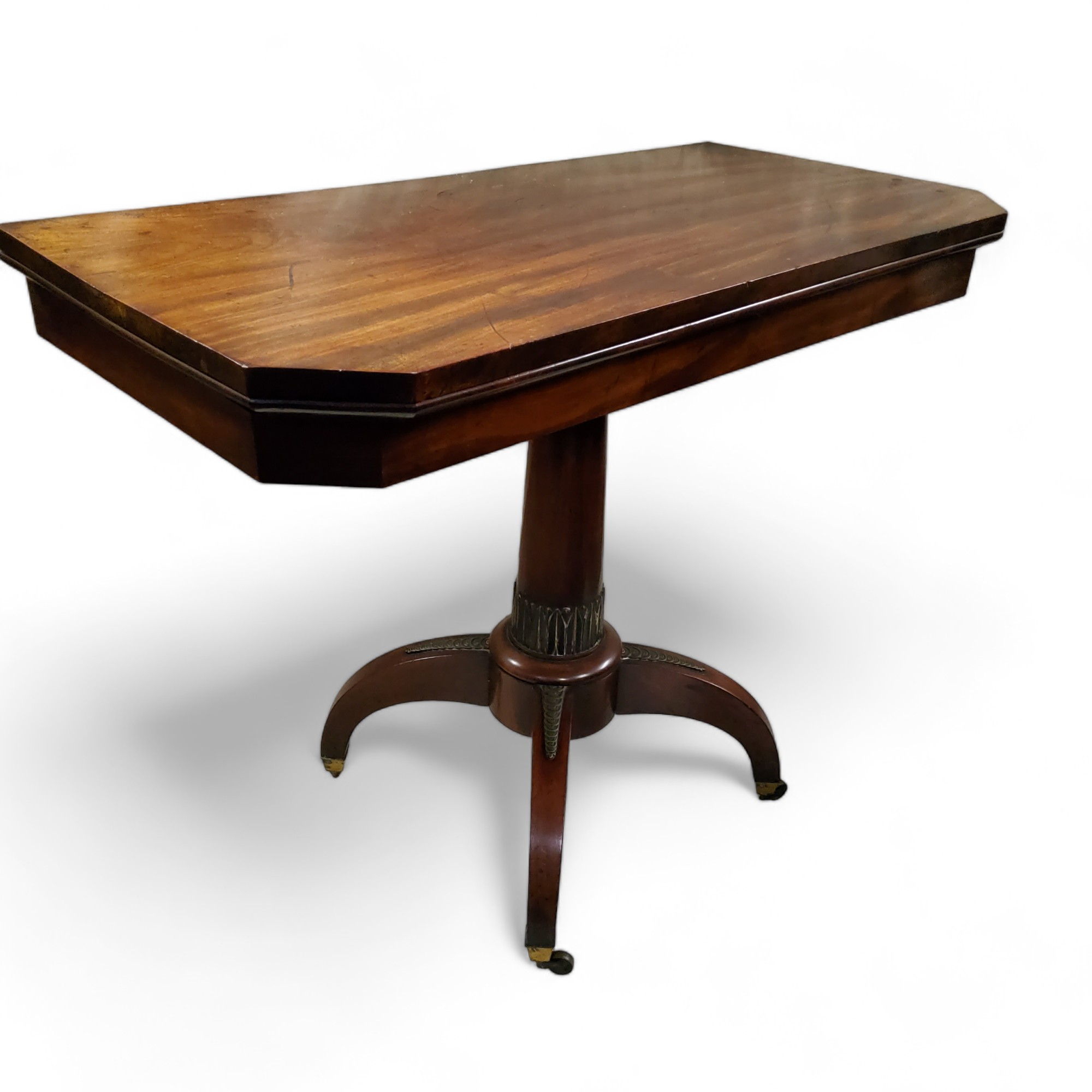 A George IV mahogany tea table, canted rectangular top, spreading cylindrical column, four scroll