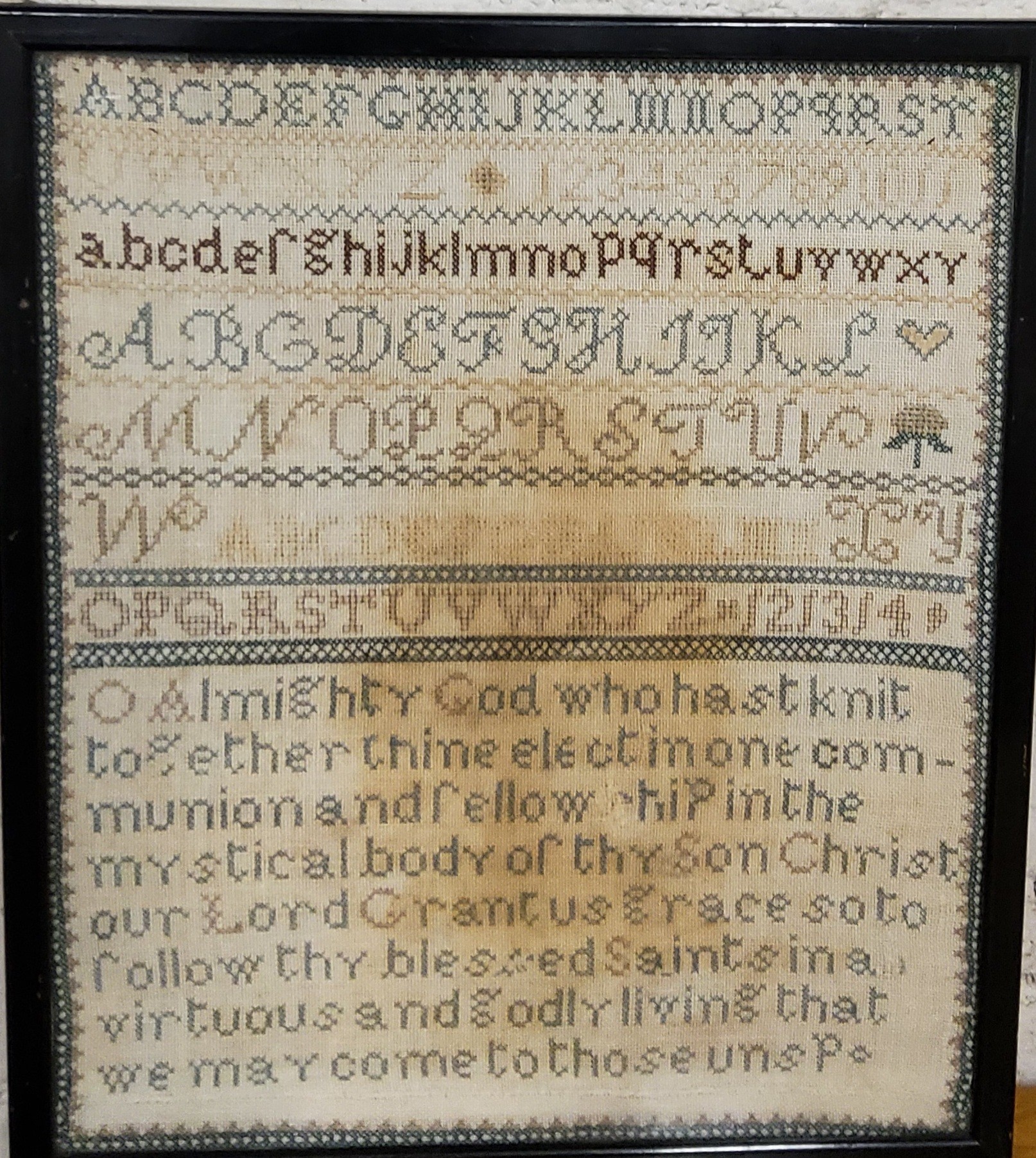 A late 19th century needlework sampler, embroidered with alphabet and verse, 32cm x 27cm, framed