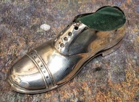 A George V silver novelty pin cushion, as a shoe, 12.5cm wide, Chester 1912