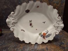 A large Chelsea silver shaped leaf dish, painted with scattered flowers and insects, iron red