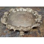 A Victorian shaped circular card waiter, crested, the field engraved with scrolling foliage, the