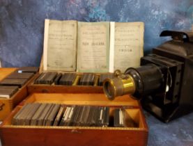 An early 20th century magic lantern projector, 29cm high, 43cm long, c.1910;  Magic Lantern Slides -