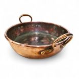 A 19th century copper two handled pan, roll top, 41cm over brass handles