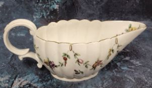 A Bristol fluted sauceboat, painted with floral swags, outlined in gilt,  the spout with leafy