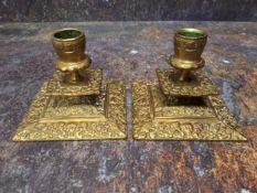 A pair of 19th century brass low candlesticks, leafy sconces, square drip plates, spreading square