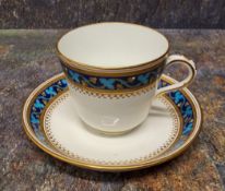 A Minton cup and saucer,  painted from designs by Christopher Dresser,  with a banded scrolling