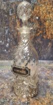 A Victorian wrythen clear glass liqueur bottle and stopper, silver sleeve, pierced with C-scrolls,