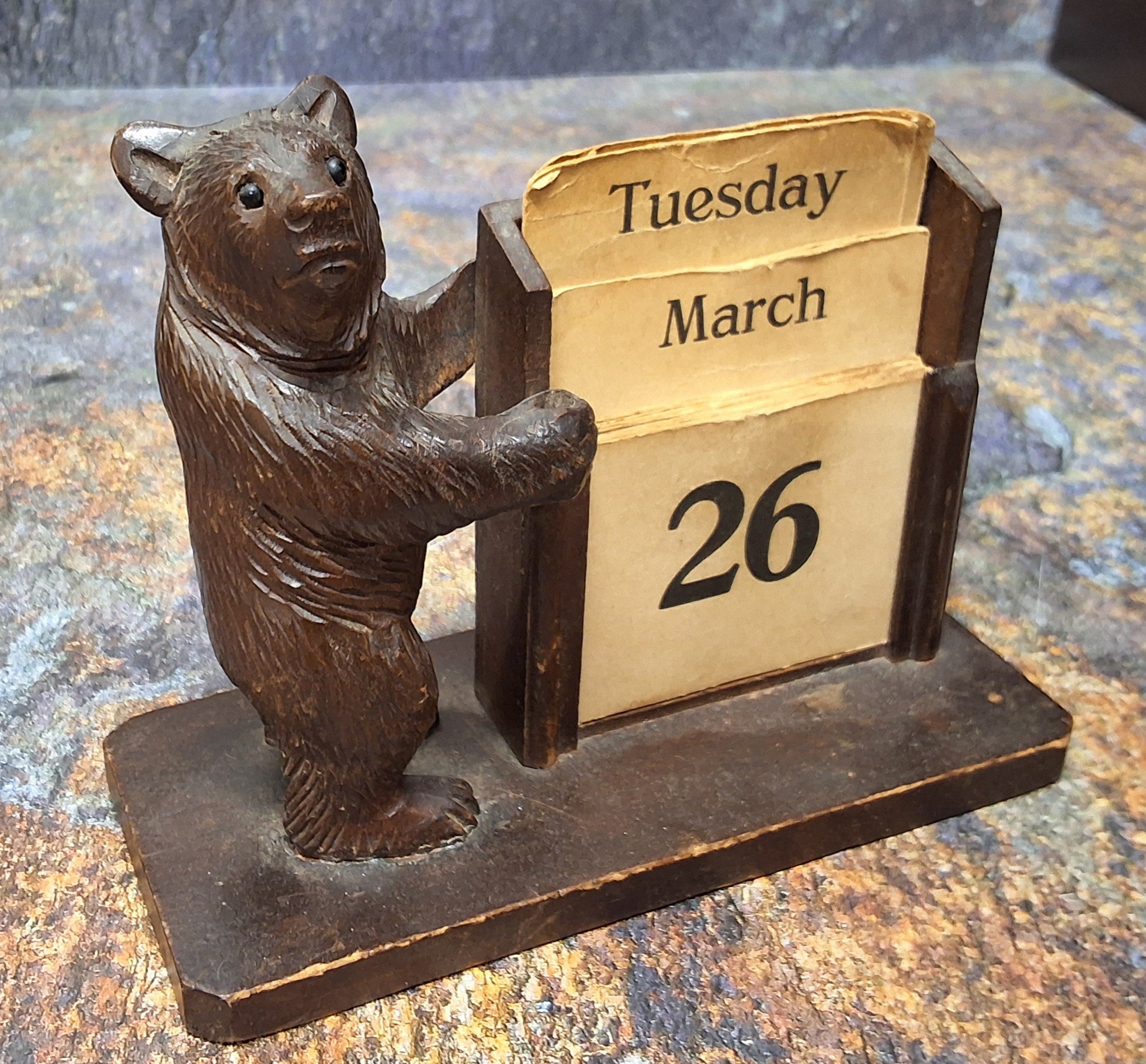 An early 20th century Black Forest bear, standing by a perpetual calendar, 11cm high, c.1900