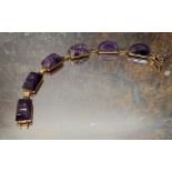 A 9ct gold Art Deco style bracelet, each link set with a polished amethyst rectangular arched stone,