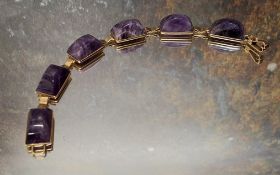 A 9ct gold Art Deco style bracelet, each link set with a polished amethyst rectangular arched stone,