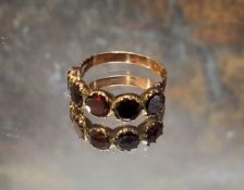 An early 19th century yellow metal and amethyst ring, set with five round amethyst stones, size O