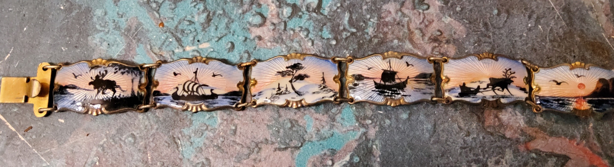 A Norwegian silver-gilt and enamel bracelet, Ivan T Holth, the panels depicting Nordic scenes, 27.