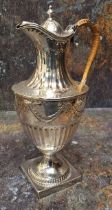 A George III silver urnular hot water pot and cover, half fluted below ribbon tied swags, domed