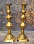A pair of early19th century brass ejector candlesticks, reel sconces, knopped columns, canted bases,