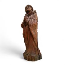 An 18th century oak carving, of a monk praying, 51cm high