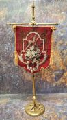 A Victorian gilt brass table banner, beadwork panel,  the column cast with scrolls, triform