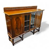 A Victorian mahogany display cabinet, glazed doors flanked by oval panel doors, tapered legs,