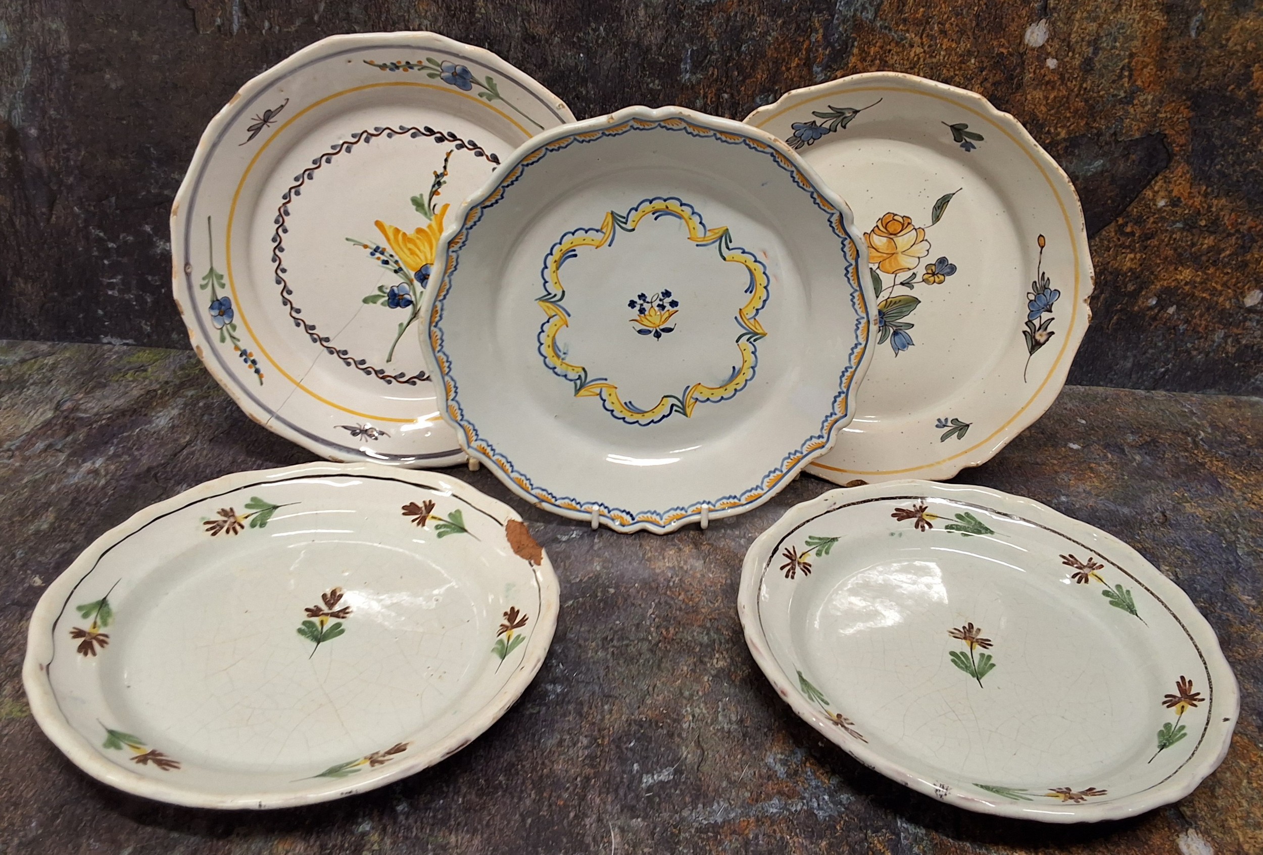 A 19th century tin glazed shaped circular plate, decorated in polychrome with stylised leaves,