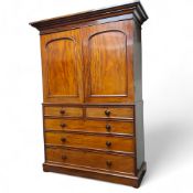 A Victorian mahogany linen press, oversailing moulded cornice above two arched paneled doors